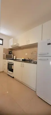 a kitchen with white cabinets and a white refrigerator at FlussHaus3 in Villa General Belgrano