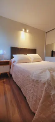 a bedroom with a large bed with a wooden floor at FlussHaus3 in Villa General Belgrano