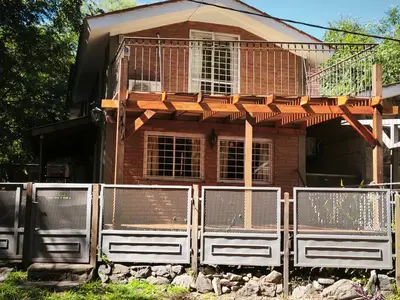 a house with a fence in front of it at Sonidos del Rio Aparts in Santa Rosa de Calamuchita