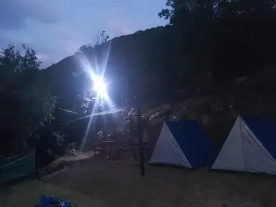 a group of tents in a field with a mountain at Campamento Monarcas in Villa Carlos Paz