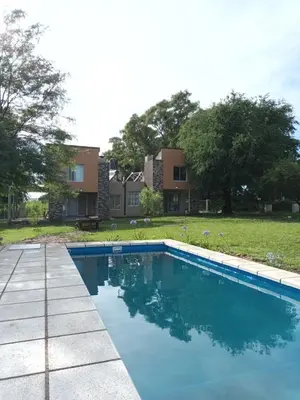 a swimming pool in front of a house at Complejo El Aguaribay in Potrero de Garay