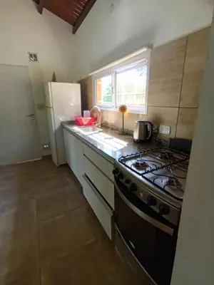 a kitchen with a stove and a refrigerator at Complejo El Aguaribay in Potrero de Garay
