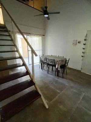 a table and chairs in a room with a staircase at Complejo El Aguaribay in Potrero de Garay