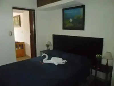 a bedroom with a bed with a swan on it at Complejo Luluara in Villa Carlos Paz