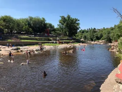 a group of people swimming in a river at Complejo Luluara in Villa Carlos Paz