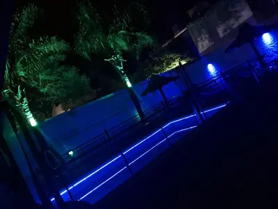 a fence with blue and green lights at night at Complejo Luluara in Villa Carlos Paz