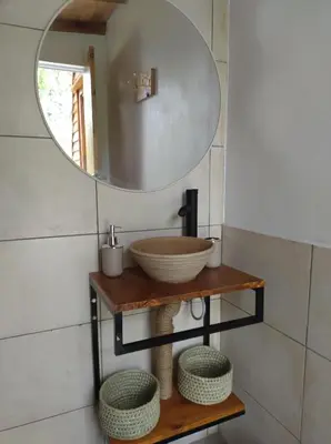 a bathroom with a mirror and a bowl on a shelf at Sens EcoRefugio in Villa Carlos Paz