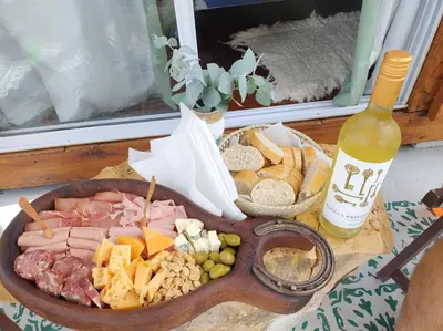a table with a plate of food and a bottle of wine at Sens EcoRefugio in Villa Carlos Paz