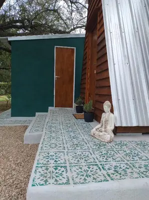 a statue sitting on a rug in front of a building at Sens EcoRefugio in Villa Carlos Paz