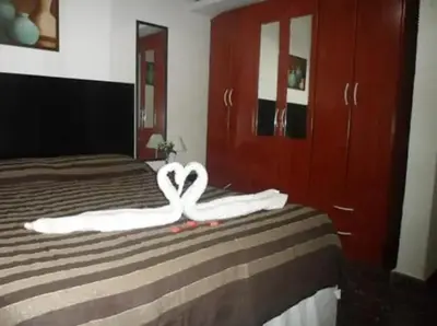a bed with two towels in the shape of a heart at Complejo Luluara in Villa Carlos Paz