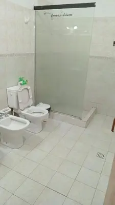 a bathroom with a toilet and a shower stall at Complejo Luluara in Villa Carlos Paz