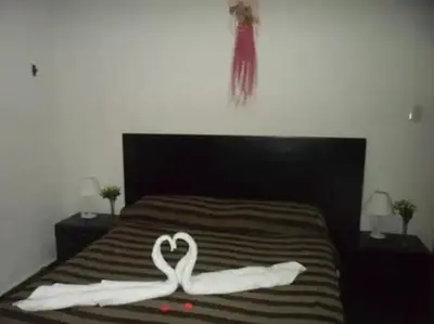 two swans making a heart on a bed at Complejo Luluara in Villa Carlos Paz
