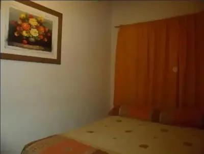 a bedroom with a bed and a painting on the wall at Complejo Luluara in Villa Carlos Paz