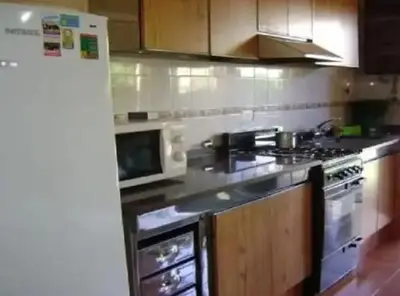 a kitchen with a stove and a microwave at Complejo Luluara in Villa Carlos Paz