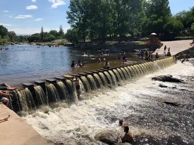 a group of people swimming in a body of water at Complejo Luluara in Villa Carlos Paz