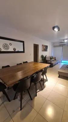 a large wooden table in a room with chairs at MAGNUS, 2 baños, 2 hab, TODO NUEVO! en el corazón de Carlos Paz in Villa Carlos Paz