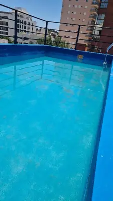 a large blue swimming pool with buildings in the background at MAGNUS, 2 baños, 2 hab, TODO NUEVO! en el corazón de Carlos Paz in Villa Carlos Paz