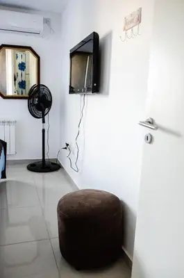 a room with a ottoman and a tv on a wall at Depto 1 dormitorio de categoria en Barrio General Paz in Cordoba