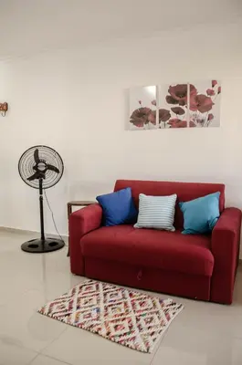 a red couch with blue pillows in a living room at Depto 1 dormitorio de categoria en Barrio General Paz in Cordoba