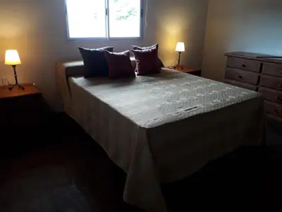 a bedroom with a large bed with two lamps at Clima Serrano in Merlo