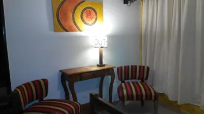 a table with two chairs and a lamp in a room at Clima Serrano in Merlo