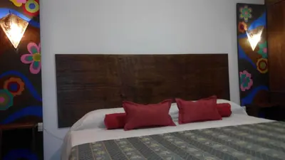 a bedroom with a large bed with red pillows at Clima Serrano in Merlo