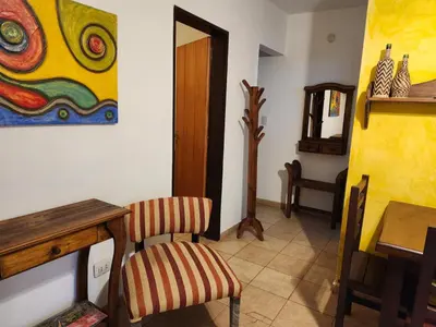 a dining room with a table and a painting on the wall at Clima Serrano in Merlo