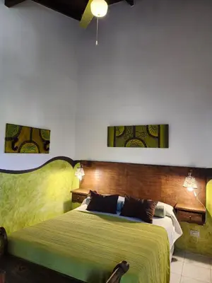 a bedroom with a large bed with a green bedspread at Clima Serrano in Merlo