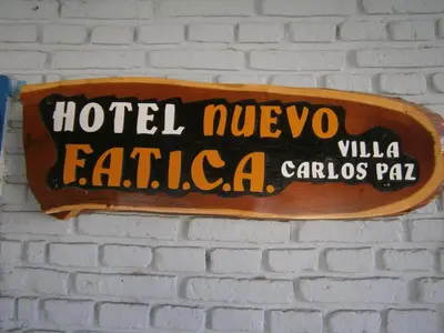 a sign hanging on a brick wall at Hotel Nuevo Fatica in Villa Carlos Paz