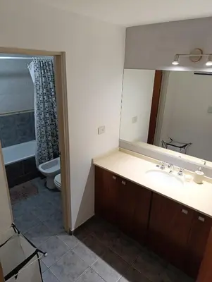 a bathroom with a sink and a mirror and a toilet at Departamento en general paz in Cordoba