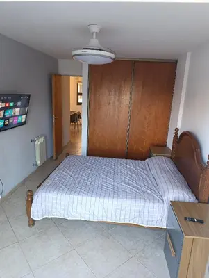 a bedroom with a large bed with a wooden headboard at Departamento en general paz in Cordoba