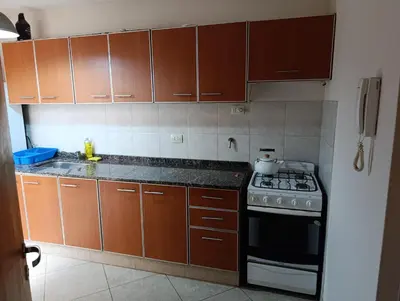 a kitchen with wooden cabinets and a stove at Departamento en general paz in Cordoba
