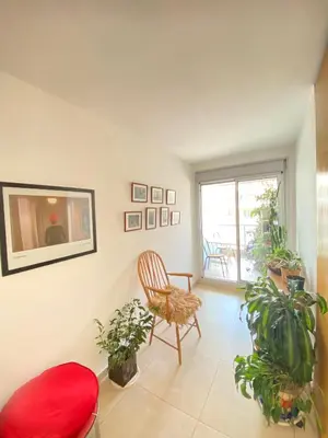 a living room with a chair and potted plants at Espacio C Jardín con estacionamiento in Cordoba
