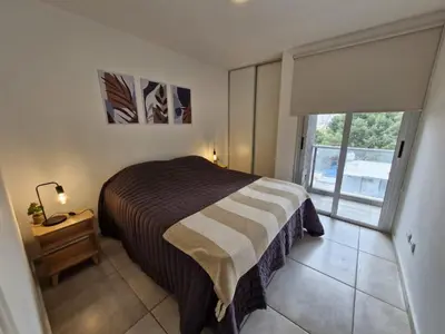 a bedroom with a bed and a window with a door at Espacio C Av PUEYRREDÓN con estacionamiento in Cordoba