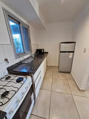 a kitchen with a stove and a refrigerator at Espacio C Av PUEYRREDÓN con estacionamiento in Cordoba