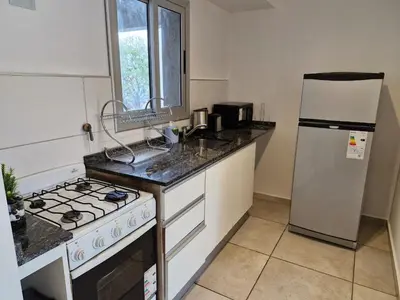 a kitchen with a stove and a refrigerator at Espacio C Av PUEYRREDÓN con estacionamiento in Cordoba