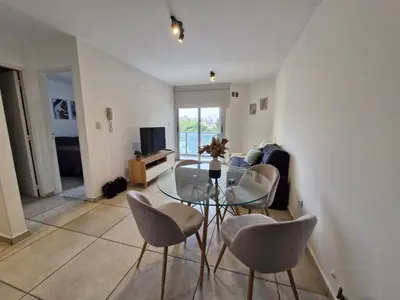 a living room with a glass table and chairs at Espacio C Av PUEYRREDÓN con estacionamiento in Cordoba