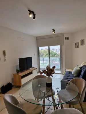 a living room with a glass table and a couch at Espacio C Av PUEYRREDÓN con estacionamiento in Cordoba