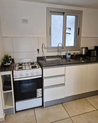 a kitchen with a stove and a sink at Espacio C Av PUEYRREDÓN con estacionamiento in Cordoba