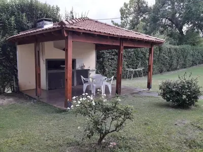 a pavilion with a table and chairs in a yard at Casa Rivadavia in Mina Clavero