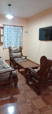 a living room with a couch and a table and a tv at Casa Rivadavia in Mina Clavero