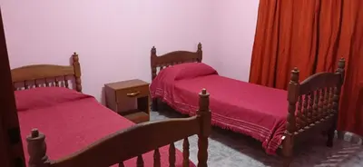 a bedroom with two beds with pink sheets at Casa Rivadavia in Mina Clavero