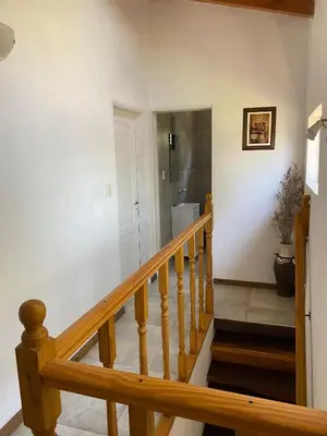 a staircase in a home with a wooden stair railing at Cabaña Rubí, Complejo El Colibrí in Villa del Dique