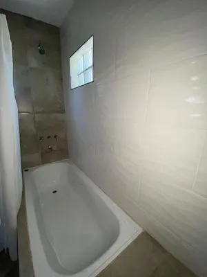 a white bath tub in a bathroom with a window at Cabaña Rubí, Complejo El Colibrí in Villa del Dique