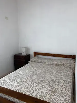 a bedroom with a bed and a night stand at Cabaña Rubí, Complejo El Colibrí in Villa del Dique