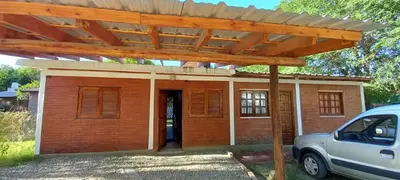 a brick house with a wooden pergola at Cabañas Mi Ángel in Villa Cura Brochero