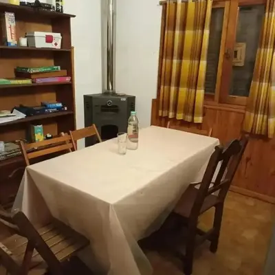 a table with a bottle and two glasses on it at Chalet los aromos in Villa Los Aromos