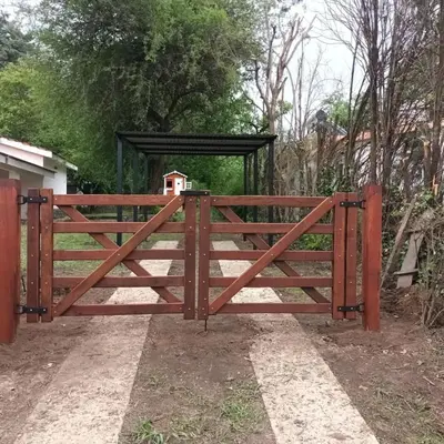 a wooden fence with a gate in a yard at Chalet los aromos in Villa Los Aromos