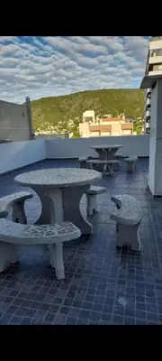 a group of tables and benches on a patio at Abuela Betty in Villa Carlos Paz