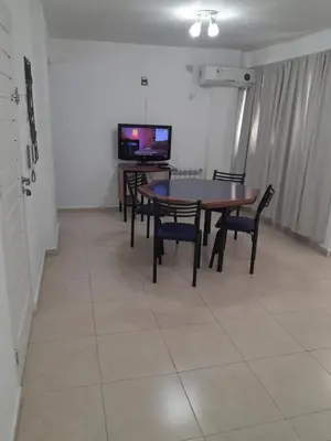 a dining room with a table and chairs and a television at Abuela Betty in Villa Carlos Paz